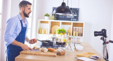 Mutfak arka planında poşet dolusu erzak tutan adam. Alışveriş ve sağlıklı gıda konsepti