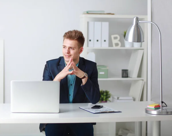 Handsome young man sitting and working on laptop computer — Stock Photo, Image