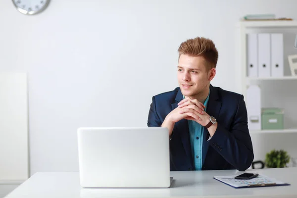 Handsome young man sitting and working on laptop computer — Stock Photo, Image