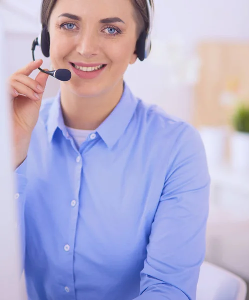 Grave bella giovane donna che lavora come operatore telefonico di supporto con auricolare in ufficio — Foto Stock