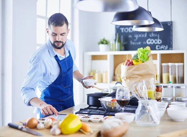 Uomo che prepara cibo delizioso e sano nella cucina di casa — Foto Stock