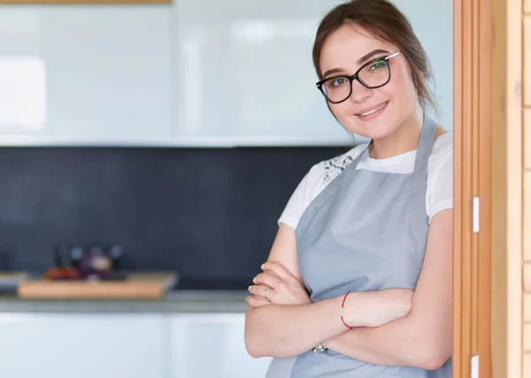 Jovem mulher de pé perto da mesa na cozinha — Fotografia de Stock