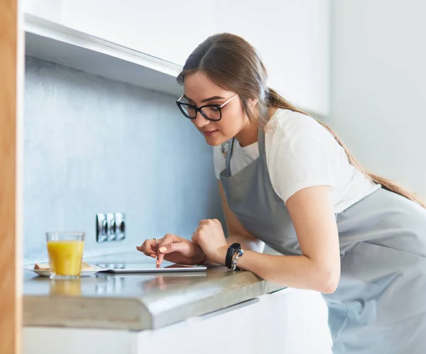 Mutfaktaki genç, beyaz tenli esmer ev kadınının portresi. Sabah bir fincan kahve ve tabletle — Stok fotoğraf
