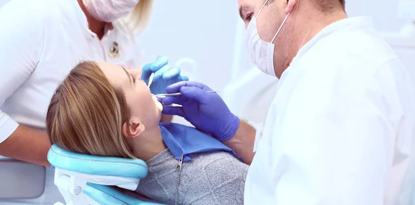 Portrait of a dentist who treats teeth of young woman patient — Stock Photo, Image