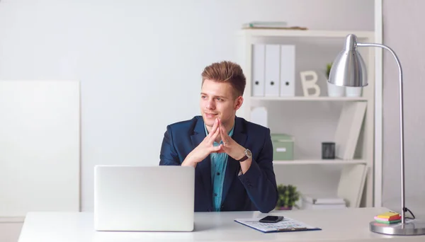 Handsome young man sitting and working on laptop computer — Stock Photo, Image