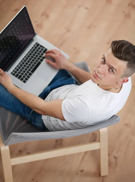 Handsome young man sitting and working on laptop computer — Stock Photo, Image