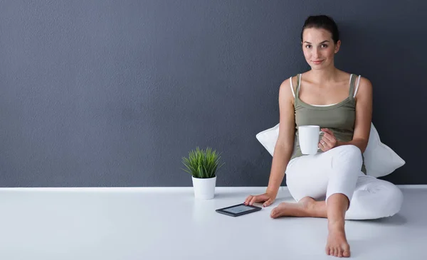 Mulher bonita sentada no chão com tablet — Fotografia de Stock