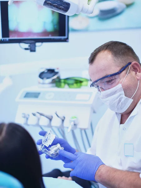 Retrato de um dentista que trata dentes de paciente jovem — Fotografia de Stock