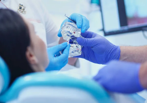 Médico dentista sênior em consultório odontológico conversando com paciente do sexo feminino e se preparando para o tratamento — Fotografia de Stock