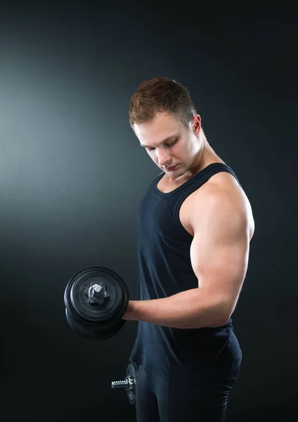 肌肉发达的年轻人在深色背景下举重时的身体闭塞 — 图库照片