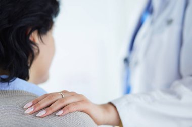 Kadın doktor bir hastaya danışmanlık yapıyor ve tıbbi bilgi ve teşhisi açıklıyor.