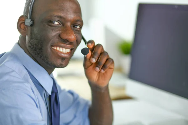 Homme d'affaires afro-américain sur casque de travail sur son ordinateur portable — Photo