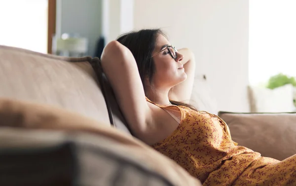 Evdeki modern bir kanepede oturan rahat kadın. — Stok fotoğraf