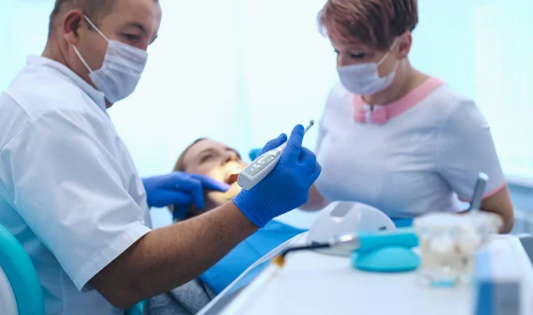 Retrato de un dentista que trata los dientes de una paciente joven — Foto de Stock