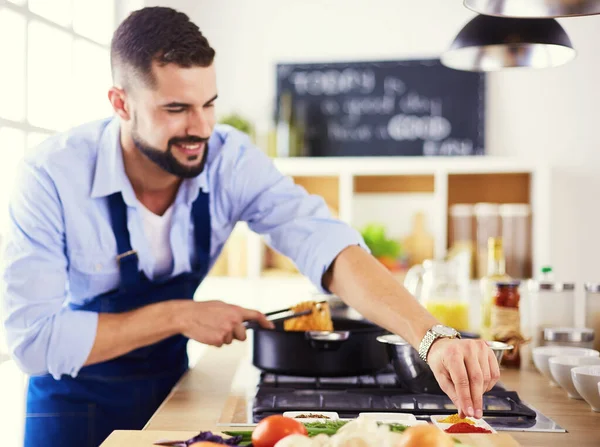 Uomo che prepara cibo delizioso e sano nella cucina di casa — Foto Stock