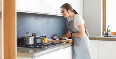 Güzel kadın, ev mutfağında lezzetli ve sağlıklı yemekler yiyor.