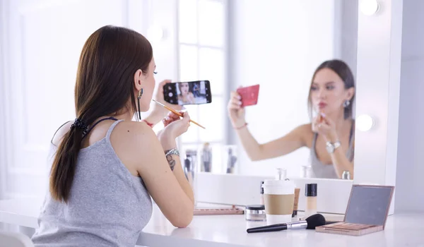 Beauty-Bloggerin filmt Make-up-Anleitung mit Smartphone vor Spiegel — Stockfoto