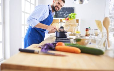 Adam ev mutfağında lezzetli ve sağlıklı yemekler hazırlıyor.