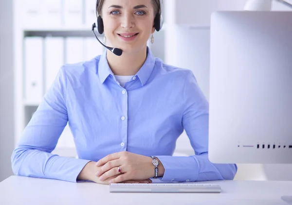 Ernsthafte hübsche junge Frau arbeitet als Telefonistin mit Headset im Büro — Stockfoto