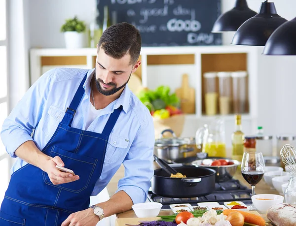 Чоловік тримає паперовий мішок повний продуктів на кухонному фоні. Концепція шопінгу та здорової їжі — стокове фото