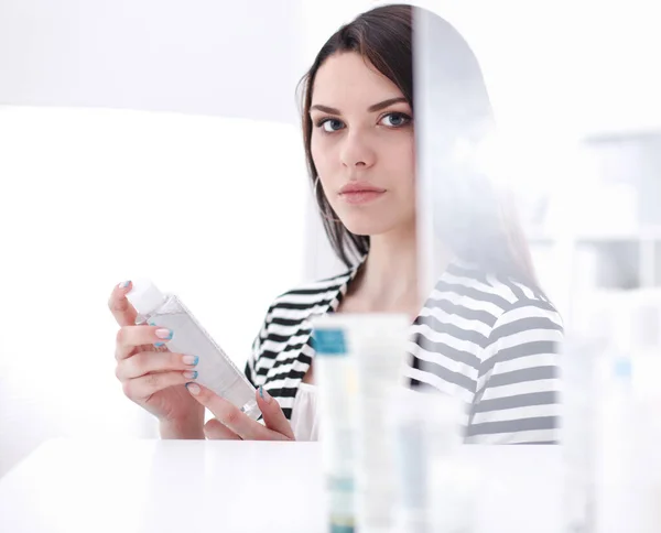 Shopping woman with bottle of shampoo in supermarket — Stock Photo, Image