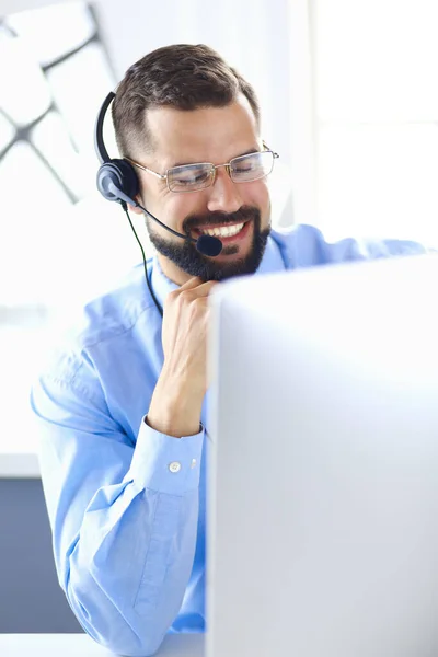 Portrait of a young man with a headset in front of a laptop computer — Stock Photo, Image