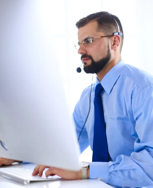 Empresario en la oficina en el teléfono con auriculares, Skype, FaceTime — Foto de Stock