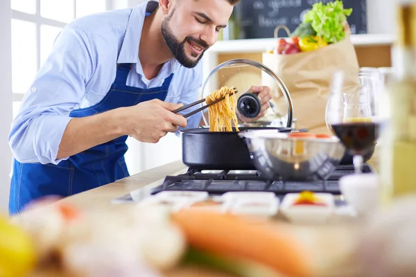 家のキッチンでおいしいと健康食品を準備する男 — ストック写真