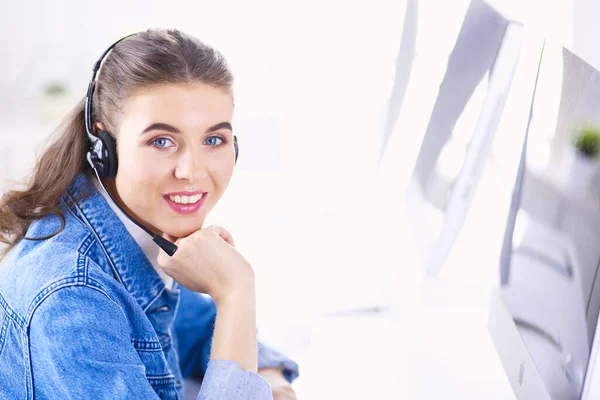 Jovem encantadora feliz sentada e trabalhando com laptop usando fone de ouvido no escritório — Fotografia de Stock