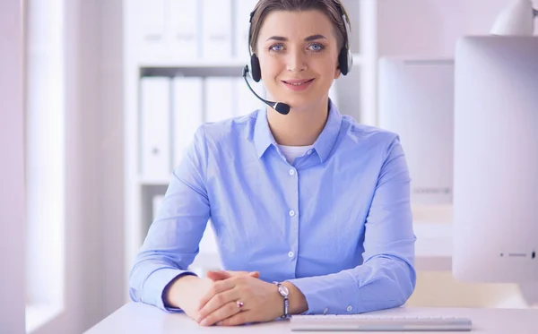 Mujer bastante joven y seria que trabaja como operador de telefonía de apoyo con auriculares en la oficina —  Fotos de Stock