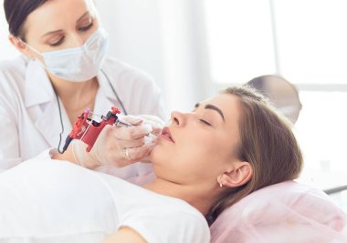 Kırmızı dudaklı genç bir kız kalıcı makyaj, mikro pigmentasyon