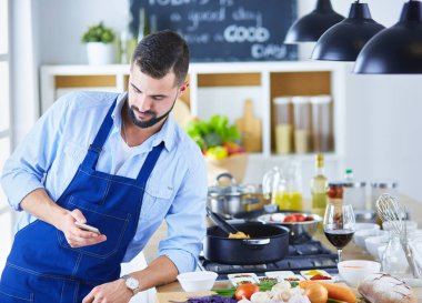 Mutfak arka planında poşet dolusu erzak tutan adam. Alışveriş ve sağlıklı gıda konsepti