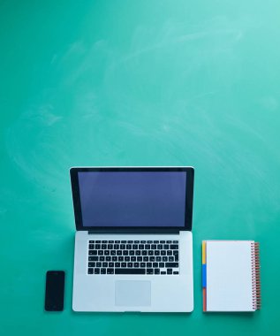 Ofis masasında dizüstü bilgisayarı ve bir sürü şeyi vardı.