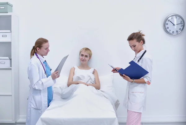 Ärztin macht sich Notizen, während Patientin spricht — Stockfoto