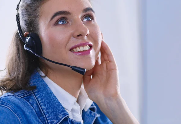 Glad charmig ung kvinna sitter och arbetar med bärbar dator med headset på kontoret — Stockfoto