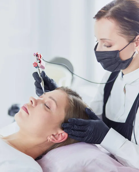 Jonge vrouw ondergaat procedure van wenkbrauw permanente make-up in schoonheidssalon — Stockfoto