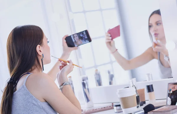 Beauty blogger filmen make-up tutorial met smartphone voor spiegel — Stockfoto