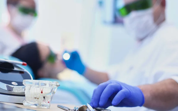 Senior male dentist adjust searchlight before starting work — Stock Photo, Image