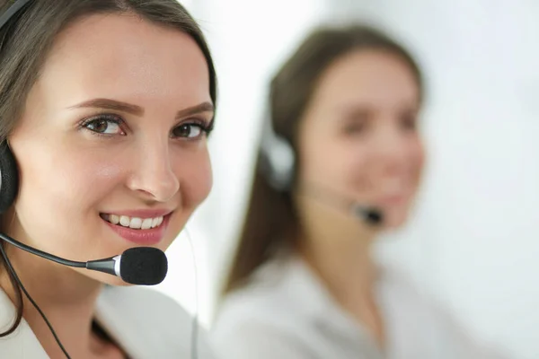 Mujer de negocios sonriente u operador de línea de ayuda con auriculares y computadora en la oficina — Foto de Stock