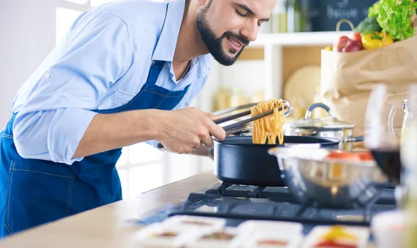 Muž připravuje lahodné a zdravé jídlo v domácí kuchyni — Stock fotografie