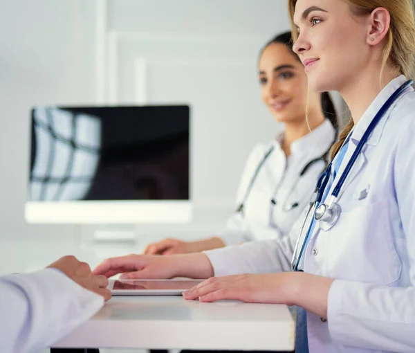 Equipe médica sentada e discutindo à mesa — Fotografia de Stock