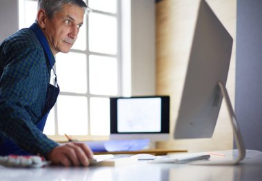 Ofisteki çizim masasında çalışan mimar