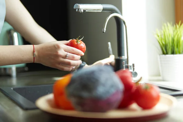 Жінка миє помідори на кухні раковина крупним планом — стокове фото