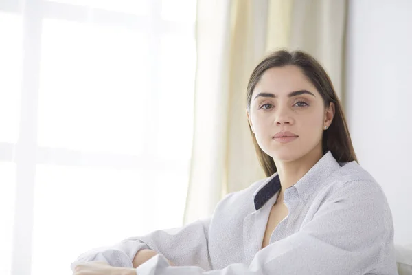 Portrait of woman using tablet and drinking coffee while sitting on the bed in the morning — Stock Photo, Image