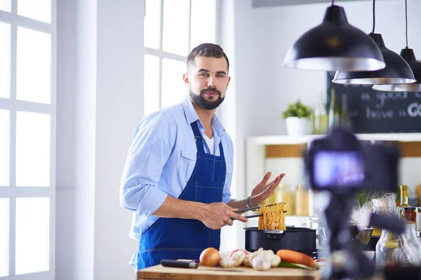 Man met papieren zak vol boodschappen op de keukenachtergrond. Winkelen en gezond voedsel concept — Stockfoto