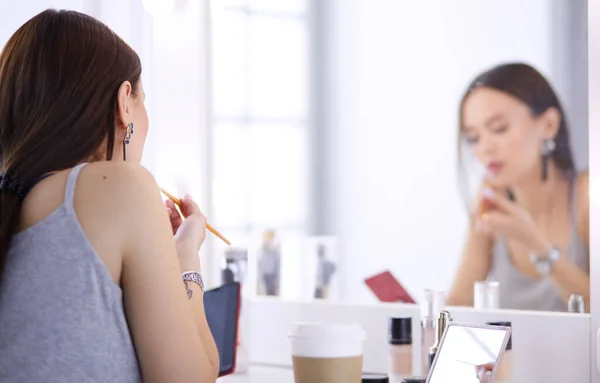 Junge Frau trägt Lippenstift vor dem Spiegel auf — Stockfoto