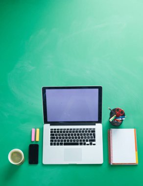 Ofis masasında dizüstü bilgisayarı ve bir sürü şeyi vardı.