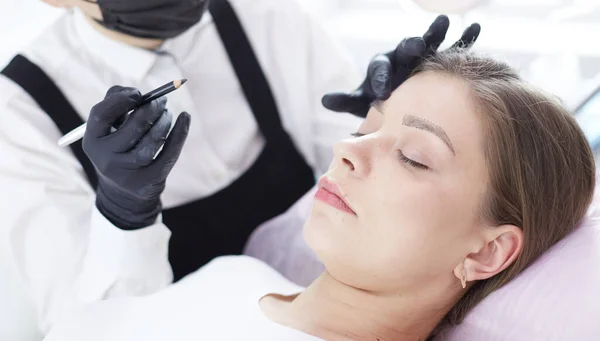 Cosmetologist applying permanent make up on eyebrows — Stock Photo, Image