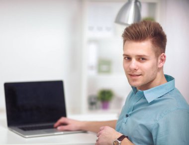 Masadaki genç adam ya da iş adamı, beyaz arka planda izole edilmiş.