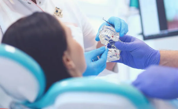 Senior mannelijke tandarts in tandheelkundige kantoor praten met vrouwelijke patiënt en voor te bereiden op de behandeling — Stockfoto